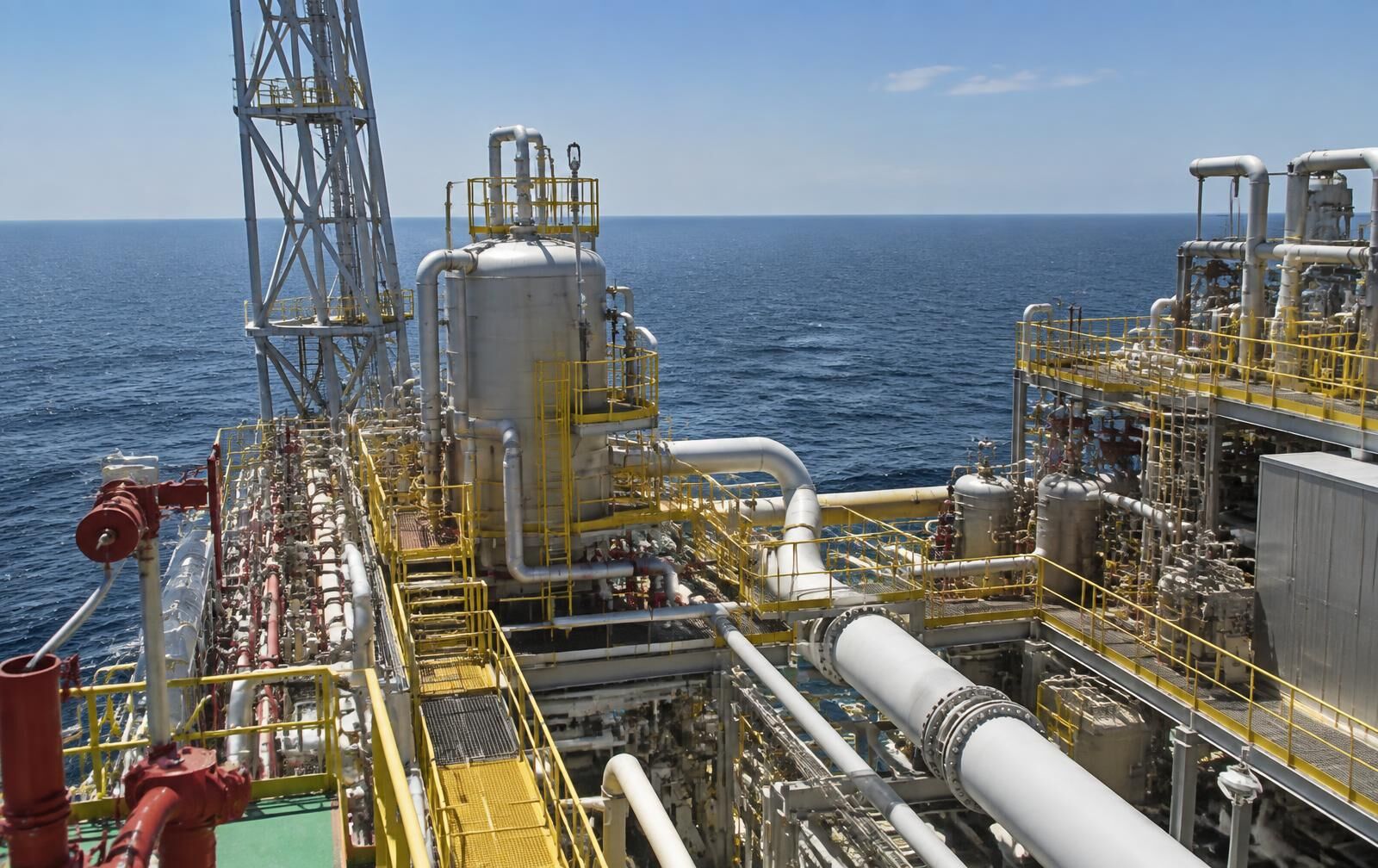Offshore platform topside process modules with piping and pressure vessels in daylight